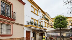 A building with a storefront, a door, and a tree in front.