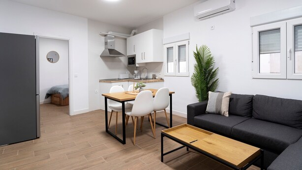 Un espace de vie compact comprenant une kitchenette, un coin repas et un coin salon.
