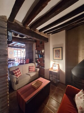 Una sala de estar acogedora con un sofá, una mesa de centro de madera y una chimenea.