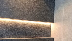 A section of dark stone tiles with a linear light fixture running horizontally. - Apartment 'Livigno' with Mountain View, Private Terrace and Wi-Fi (Livigno)