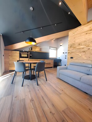A modern interior with a dining area, kitchen, and seating space. - Apartment 'Livigno' with Mountain View, Private Terrace and Wi-Fi (Livigno)