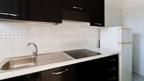 Una cocina con pileta, estufa y refrigerador.