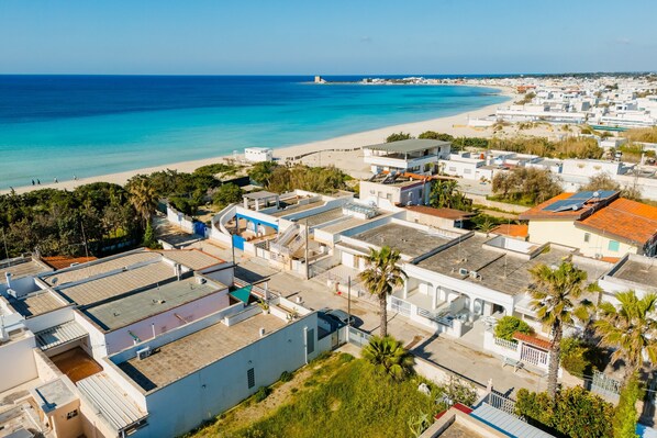 Une zone résidentielle côtière avec des bâtiments, une plage et un ciel dégagé.