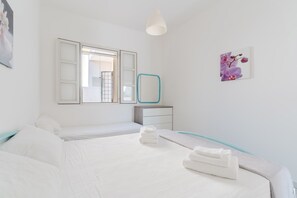 Une chambre d’hôtel avec un lit, une table de chevet, un miroir et un tableau accroché au mur.