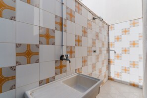 Une salle de bain avec des carreaux décorés, une baignoire et un espace douche.