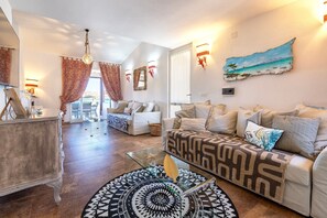 Un salon avec un canapé, une table basse et un tapis à motifs.
