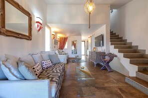 Un vaste espace de vie comprenant un canapé, une table basse et un escalier.