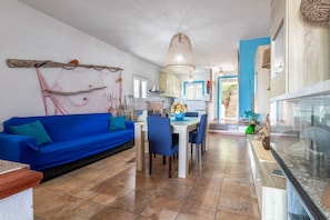Una cocina moderna con comedor, un sofá azul y una red decorativa en la pared.