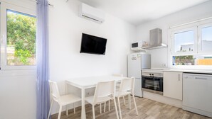 Une cuisine moderne avec des meubles blancs, un four encastré et un four à micro-ondes.