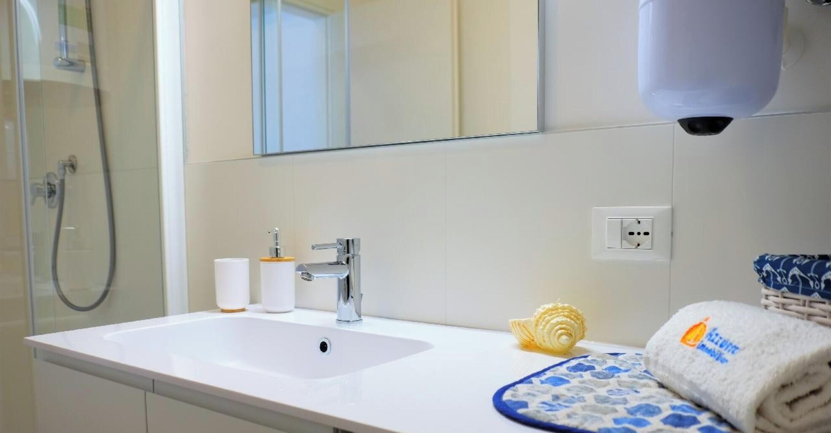 A bathroom with a sink, mirror, and towel rack.