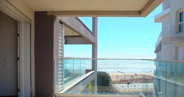 Varanda com vista ampla para a praia e o oceano.