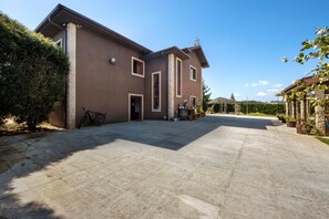 A large building with a spacious driveway, a bicycle, and potted plants. - Holiday Home 'Casa Chocolate' with Mountain Views, Private Pool and Wi-Fi (Porto)