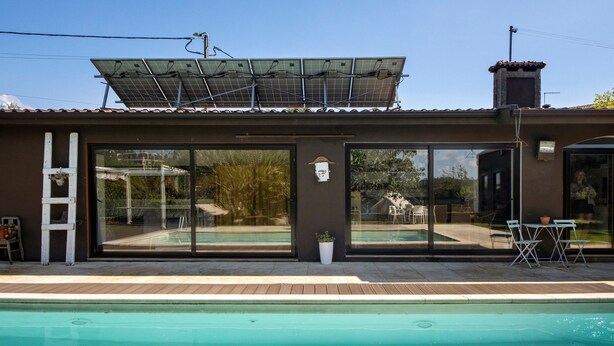 A modern building with a swimming pool, large glass doors, and solar panels on the roof. - Holiday Home 'Casa Chocolate' with Mountain Views, Private Pool and Wi-Fi (Porto)
