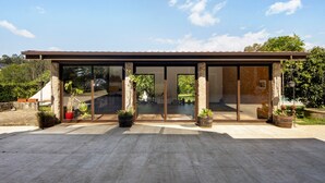A modern house with large glass doors, a patio area, and potted plants. - Holiday Home 'Casa Chocolate' with Mountain Views, Private Pool and Wi-Fi (Porto)