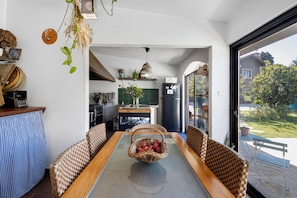A dining area with a glass table, wicker chairs, and a basket of apples. - Holiday Home 'Casa Chocolate' with Mountain Views, Private Pool and Wi-Fi (Porto)