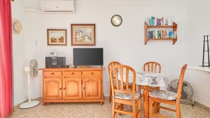 Un coin repas comprenant un buffet en bois, un téléviseur et une bibliothèque.