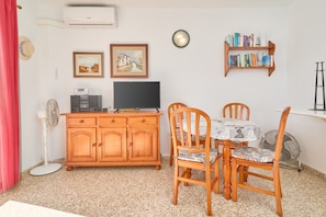 Ein Essbereich mit Holzschrank, Fernseher und Bücherregal.