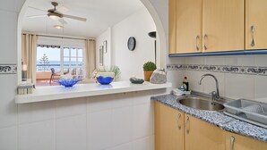 A kitchen with a white countertop, a sink, and wooden cabinets. - Apartment 'Jardines Del Mar' with Sea Views, Private Terrace and Wi-Fi (Torrox)