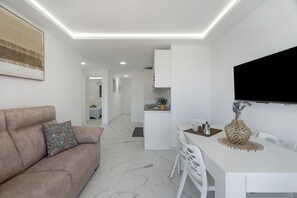 Un espacio habitable moderno con sofá, mesa de comedor y área de cocina.