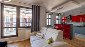 A modern apartment with a living room, kitchen, and large windows. - Dream 14 Przytulne Studio Centrum Bydgoszczy (Bydgoszcz)