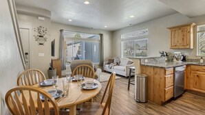 A modern kitchen with wooden cabinets, a granite countertop, and a dishwasher. - Hill Field 2 by CDH in Layton (Layton)