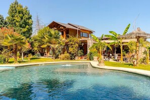 A pool area with a wooden house and tropical plants. - Wonderful large family cottage (Curacavi-Lolenco)