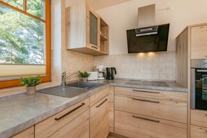 A modern kitchen with wooden cabinets, a stainless steel sink, and a built-in oven.