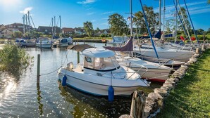A marina with boats docked along a grassy embankment.