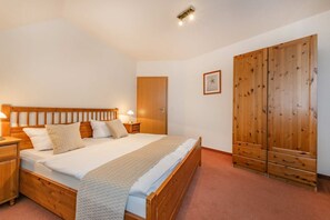 Una camera da letto con un letto in legno, comodini, un armadio e un quadro appeso al muro.