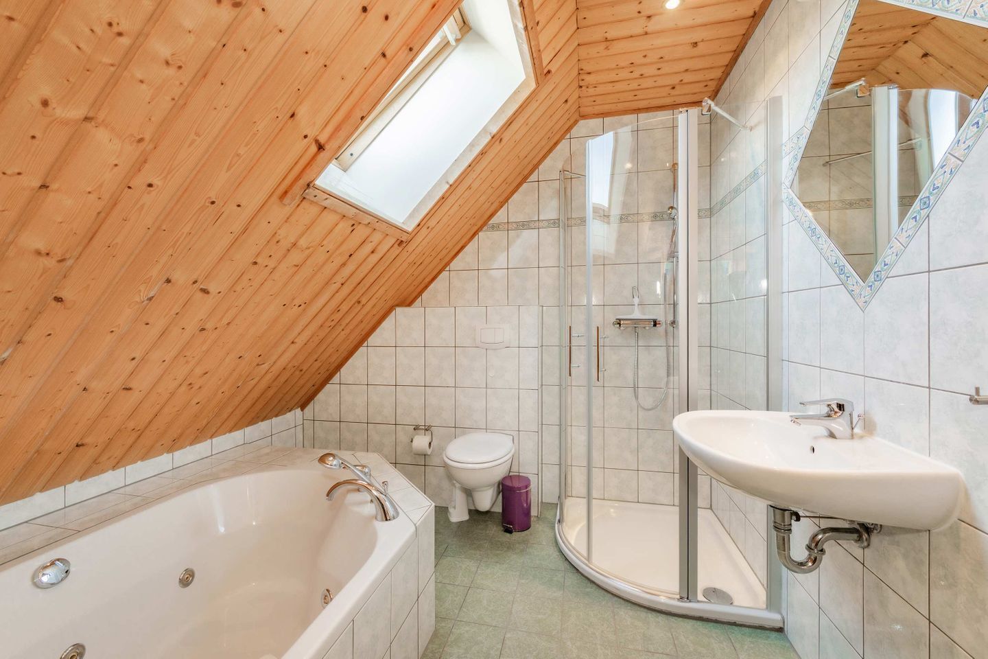 Une salle de bain avec un plafond en bois, une baignoire, une douche, des toilettes et un lavabo.