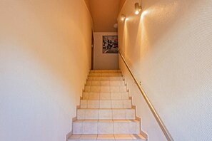 Una escalera con paredes color beige y barandilla.