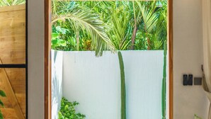 Ein Holztürrahmen führt zu einem Poolbereich mit zwei Sitzsäcken und Topfpflanzen.