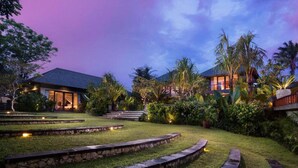 A resort with multiple buildings, well-maintained gardens, and a stone pathway.