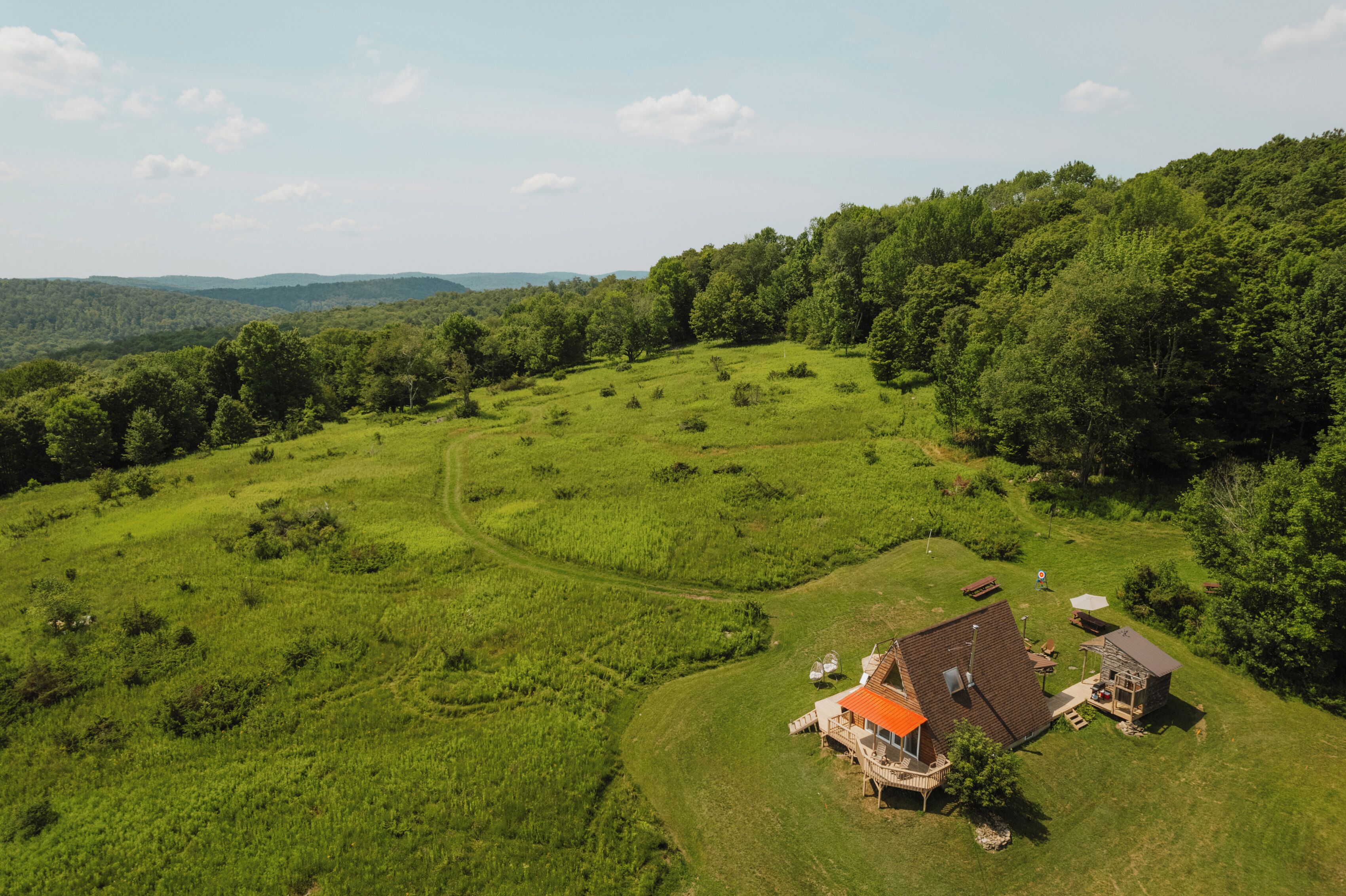 Uma propriedade rural com casa, um pequeno anexo e um gramado bem cuidado.