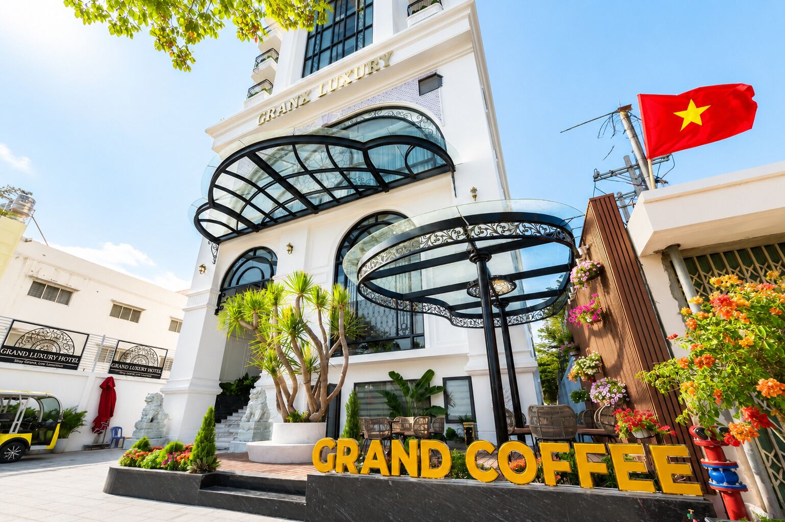 A hotel with a grand entrance, a glass facade, and a flag.
