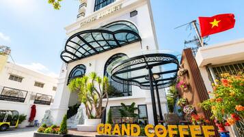 A hotel with a grand entrance, a glass facade, and a flag.
