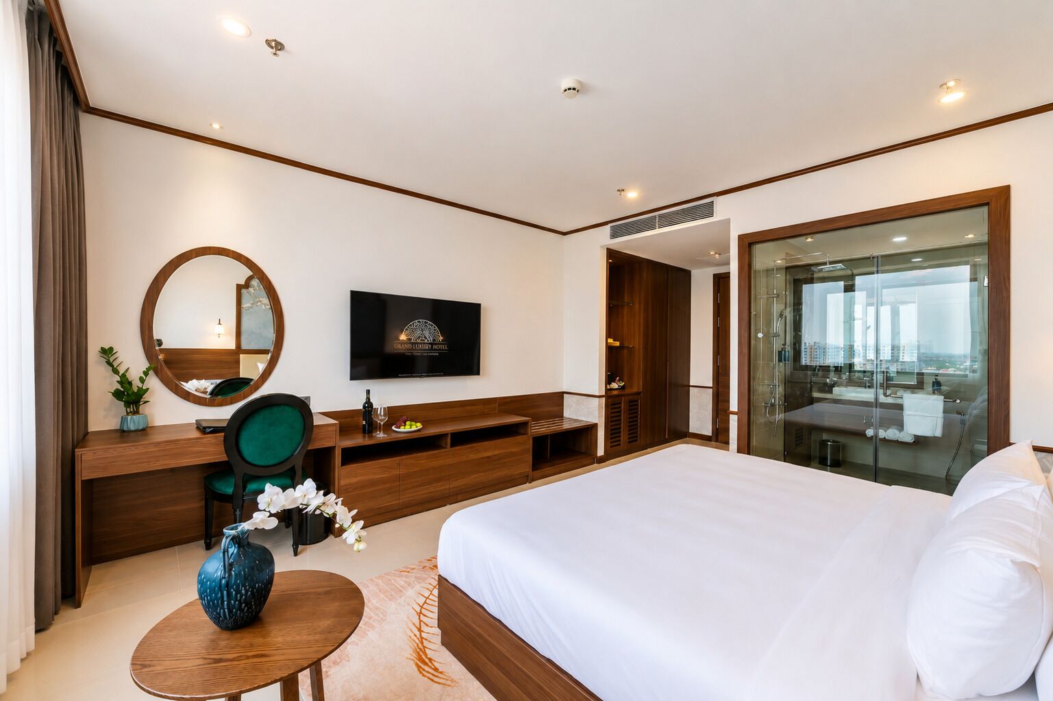 Una habitación de hotel con cama, escritorio, silla, televisor y un amplio ventanal.