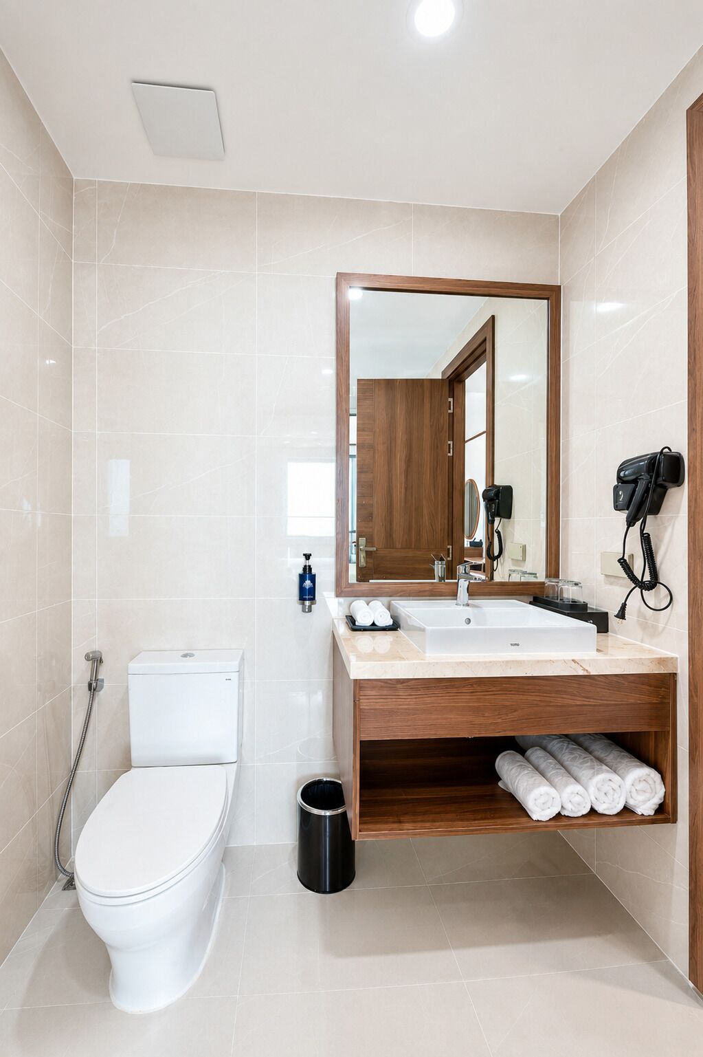 Ein modernes Badezimmer mit Toilette, Waschbecken und Spiegel.