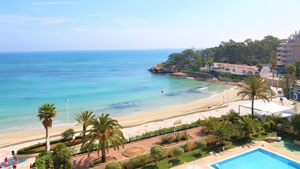 A coastal hotel with a pool, beach access, and a view of the sea.