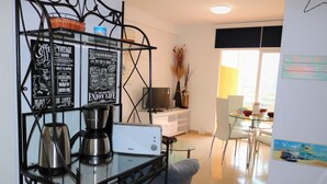 A modern kitchen with a coffee maker, toaster, and decorative signs on the wall.