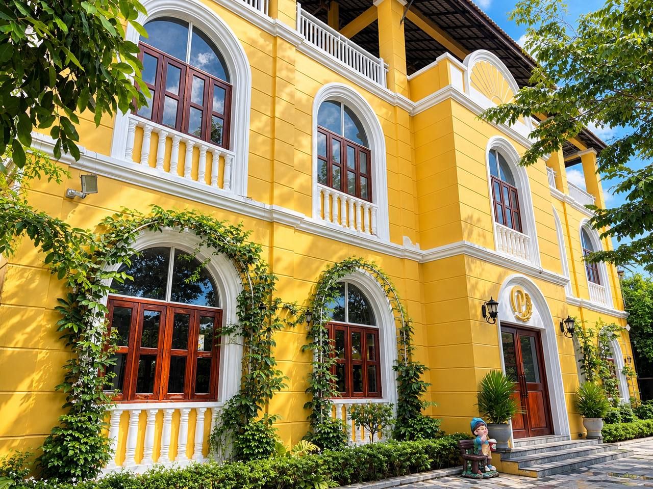 A yellow building with arched windows and a balcony.