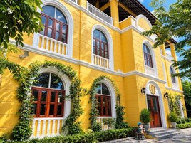 Un edificio amarillo con ventanas arqueadas y un balcón.
