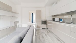 A modern kitchen with white cabinetry, a built-in oven, and a microwave. - GuestHost - MM5 Isola Bright Apartment (Milano)