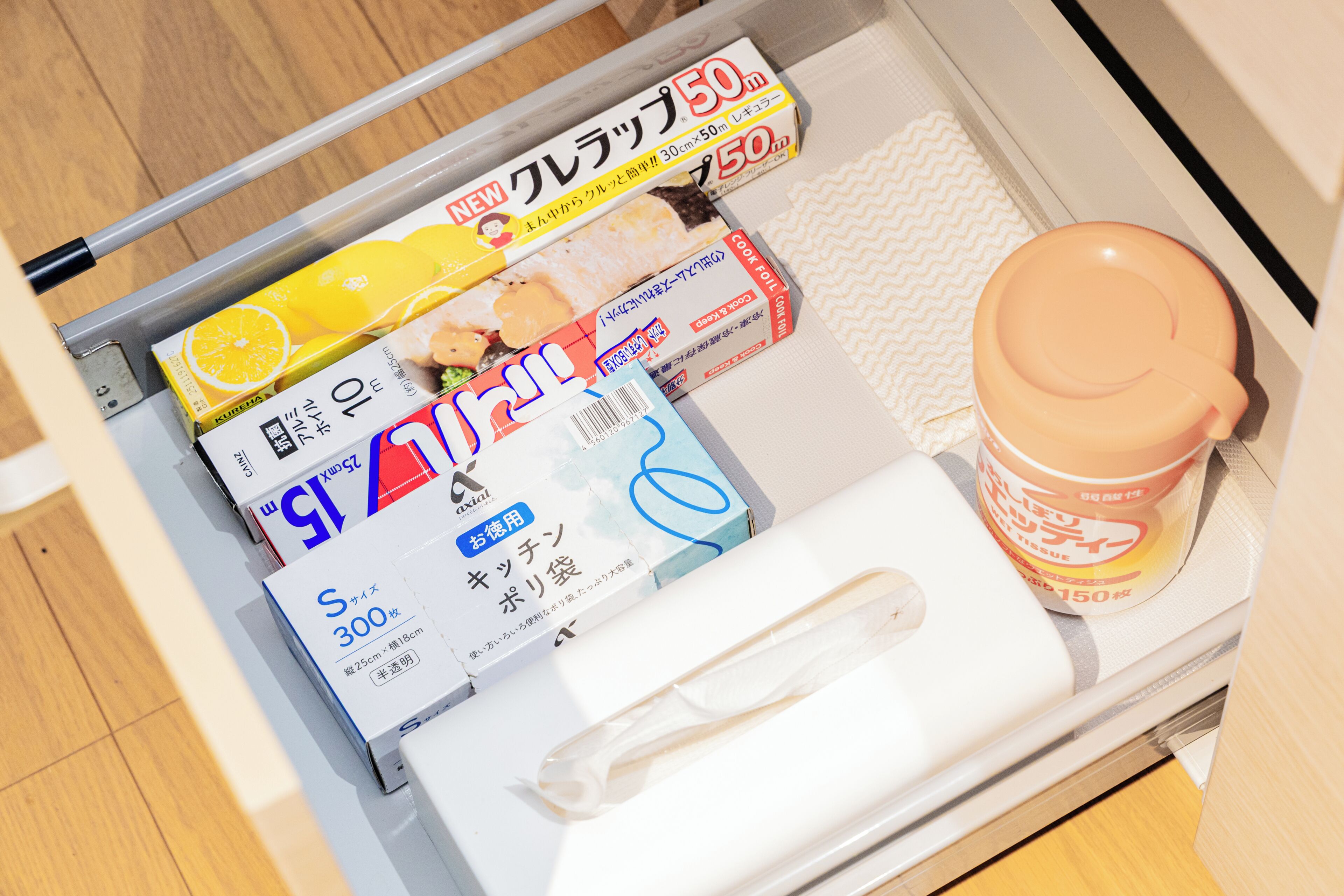 A drawer with various items including a box labeled 'S 300,' a 'NEW' box with a lemon image, and a 'COOKING' box.