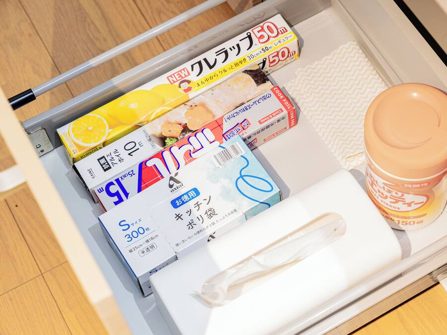 A drawer with various items including a box labeled 'S 300,' a 'NEW' box with a lemon image, and a 'COOKING' box.
