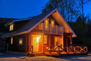 A wooden cabin with a balcony, a front door, and a porch area. - Apple farm glamping villa HARASAWA (Minakami)