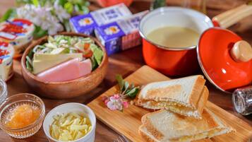 Una mesa de madera con un sándwich, un tazón de ensalada, un tazón de queso, un tazón de mostaza y una olla de sopa.
