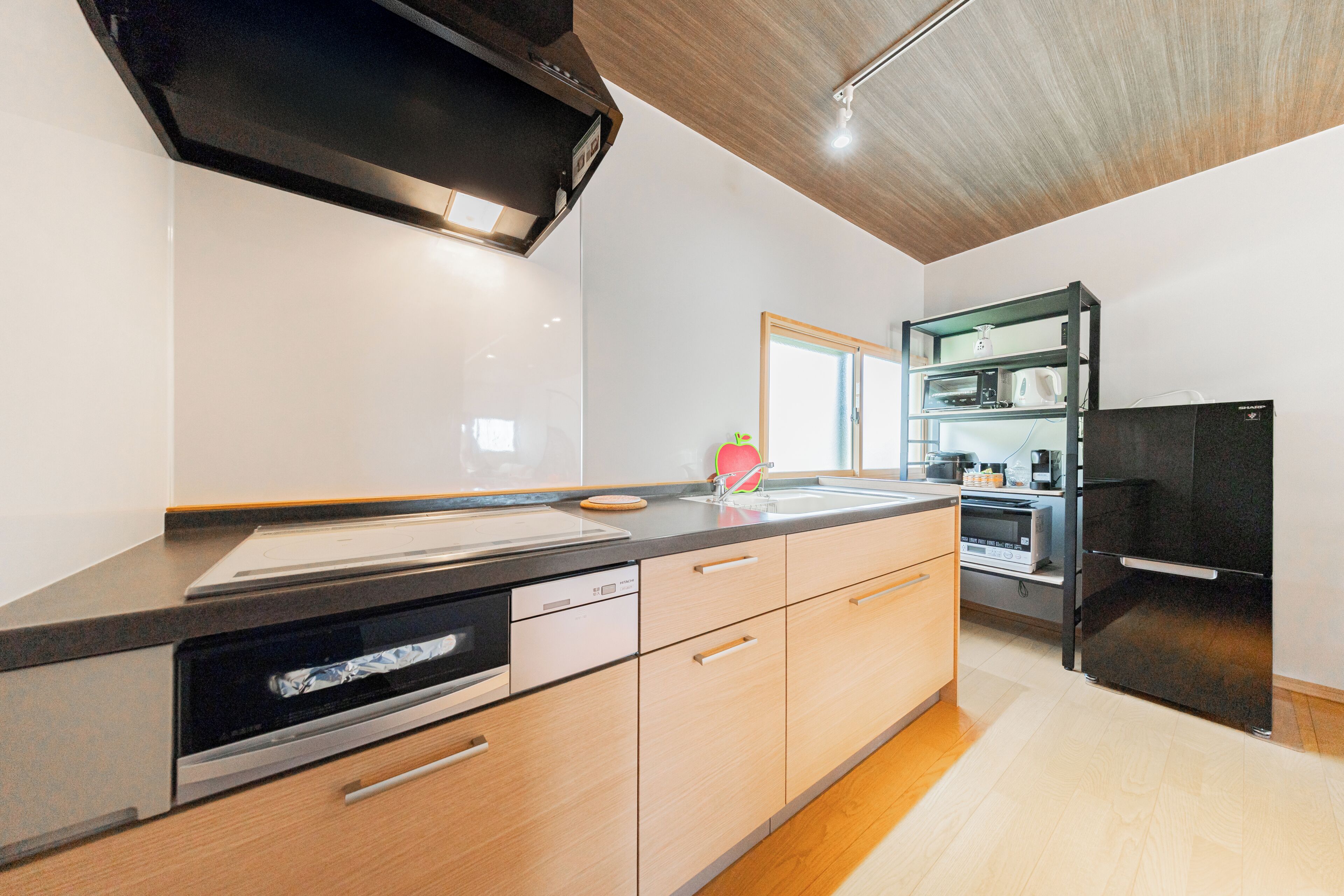 A modern kitchen with a built-in oven, a microwave, and a refrigerator.