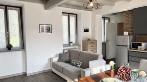 Un espacio habitable moderno con sofá, mesa de comedor y zona de cocina.