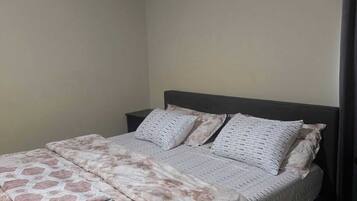 Ein Schlafzimmer mit Bett, Nachttisch und dunkelbraunem Kopfteil.